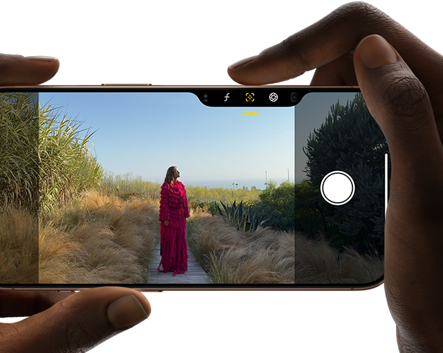 User holding iPhone 16 Pro and taking a photograph