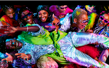 Colourful screen on a MacBook Pro of a person crowdsurfing at a party, showcasing the vibrant Liquid Retina XDR display