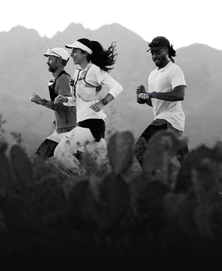 Three people running in a mountainous area, all wearing Apple Watch Ultra 3